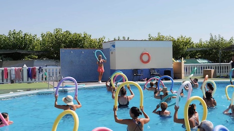 Monitora guiando a campistas en la piscina