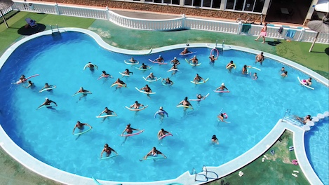 Monitora guiando a campistas en la piscina
